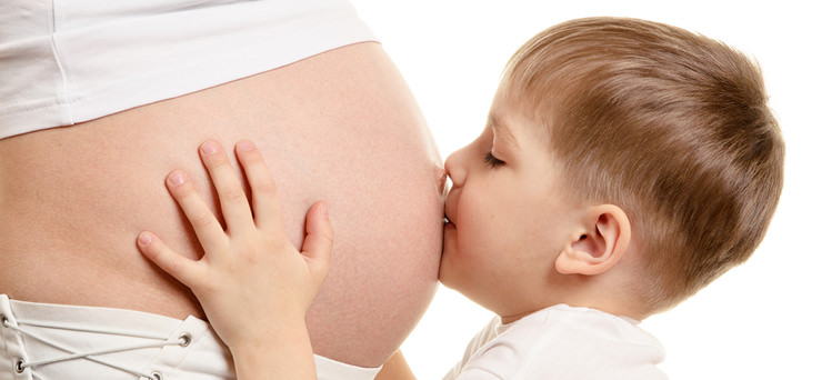 jongen kust zwangere buik